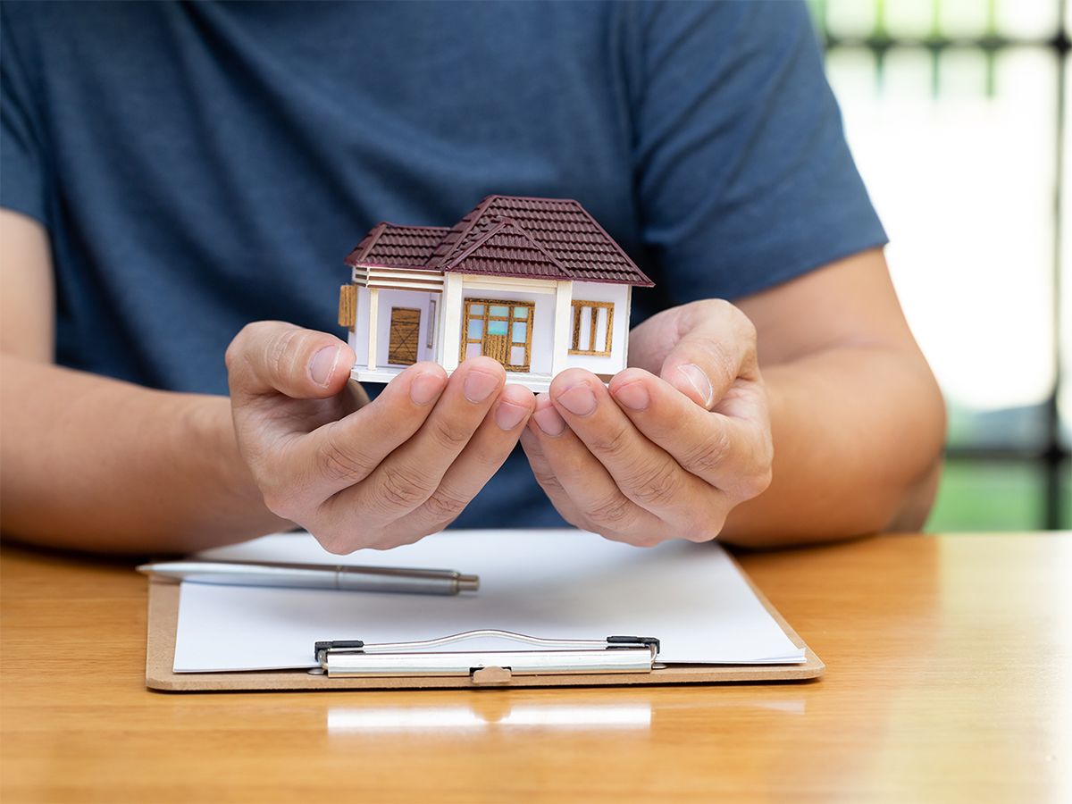 Home mortgage concept. Man holding a toy house in his hands.