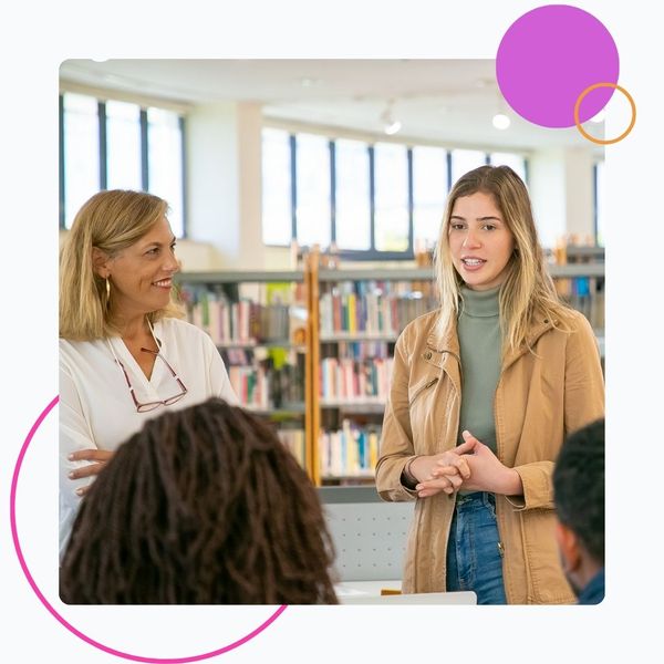 teachers talking to students in library