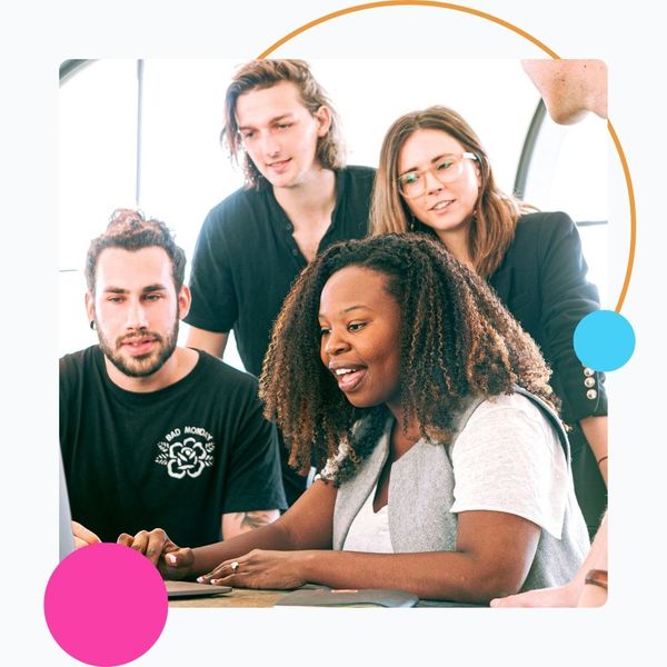 happy coworkers around one laptop