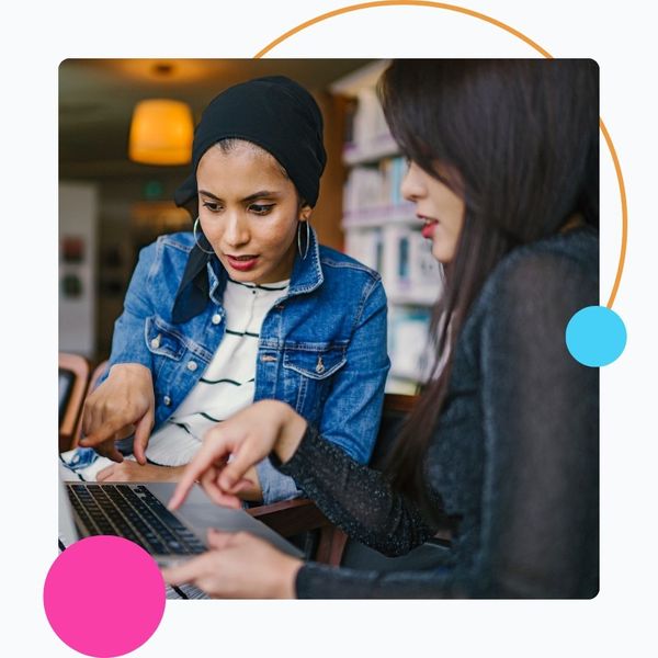 two women consulting on laptop