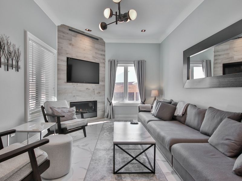 A spacious grey sectional sofa paired with a sleek, marble-topped coffee table with a black metal frame.