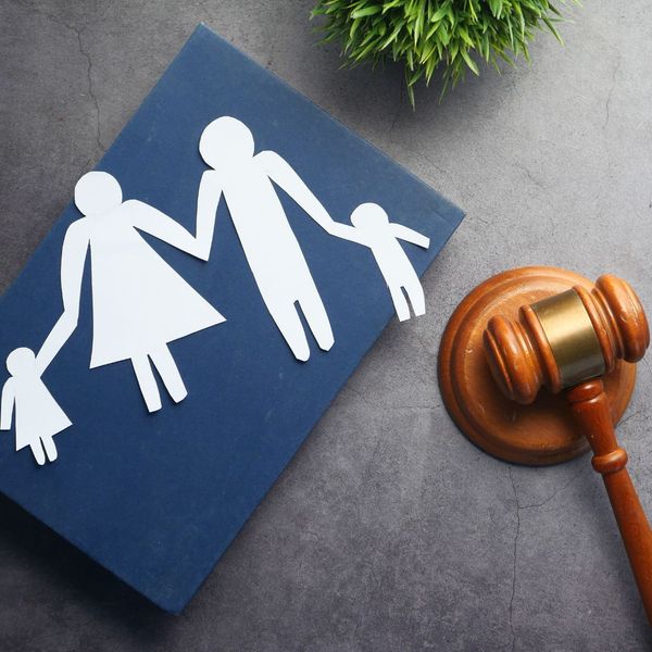 Paper cut-outs of a family next to a gavel. 