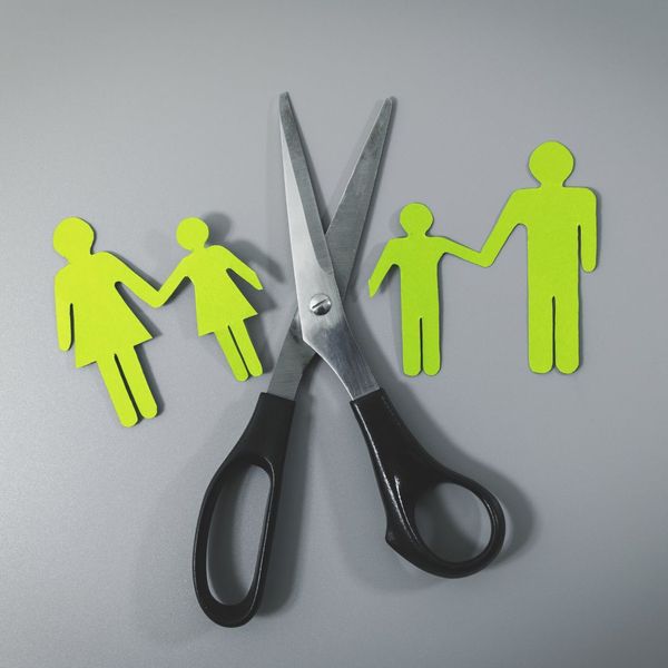 Green cut-outs of a family with scissors in between. 