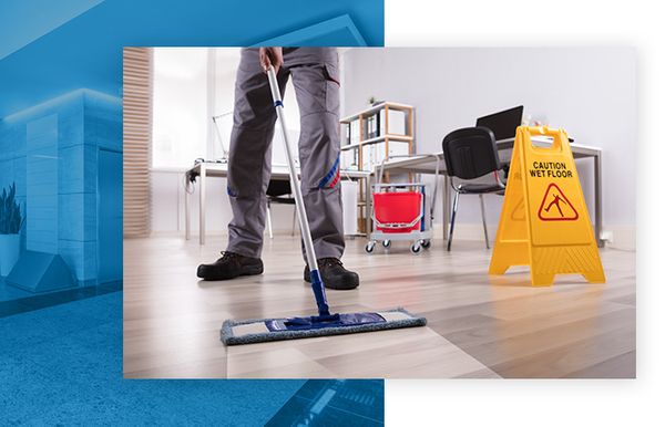 Janitor cleaning hardwood floor in an office