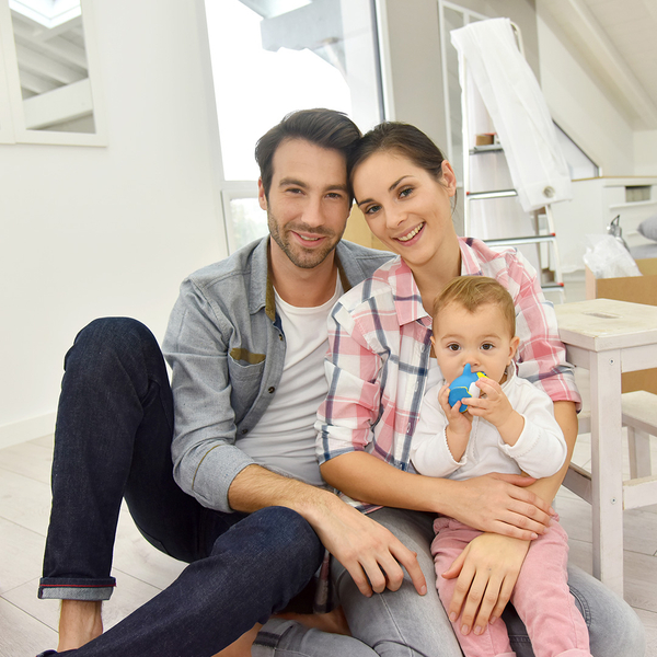 A young couple with a baby sitting in an apartment