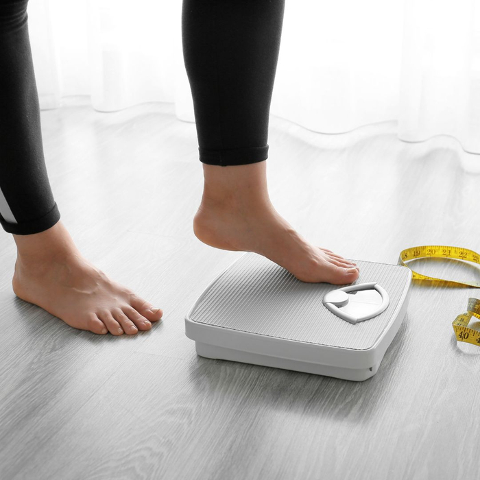 woman stepping on scale