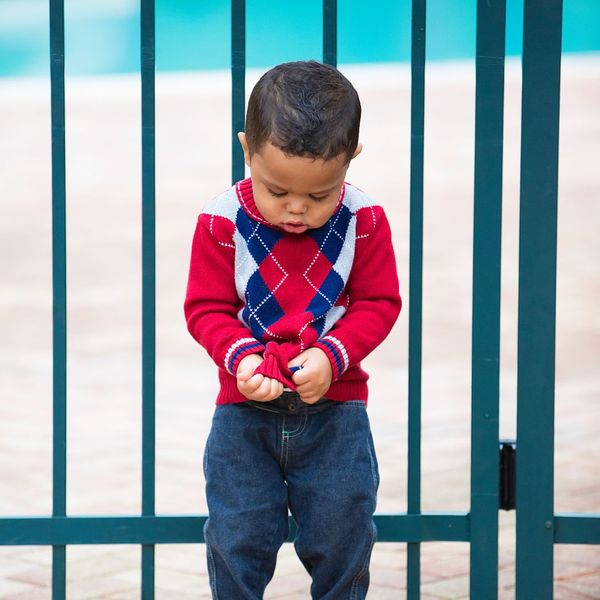 child in front of a gate