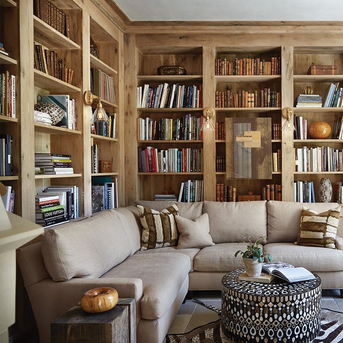 basement den with bookshelves, couch, and wall sconce