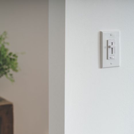 A white sliding dimmer switch on a plain wall.