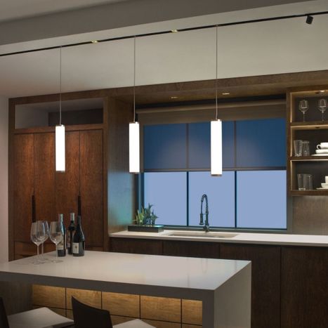 Modern cylindrical pendant lights over a dark wood kitchen.
