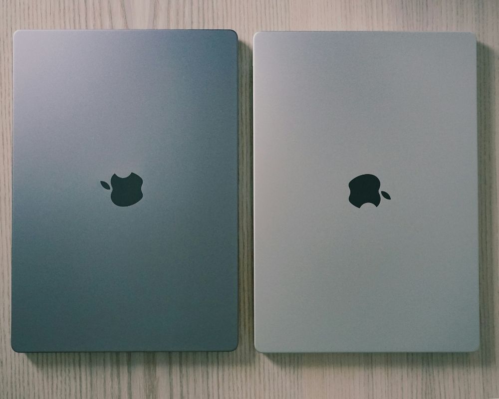 Two silver Apple MacBook laptops placed side-by-side, showcasing high-quality Apple hardware.