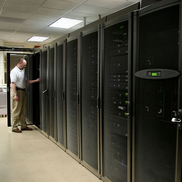 man standing at row of data servers