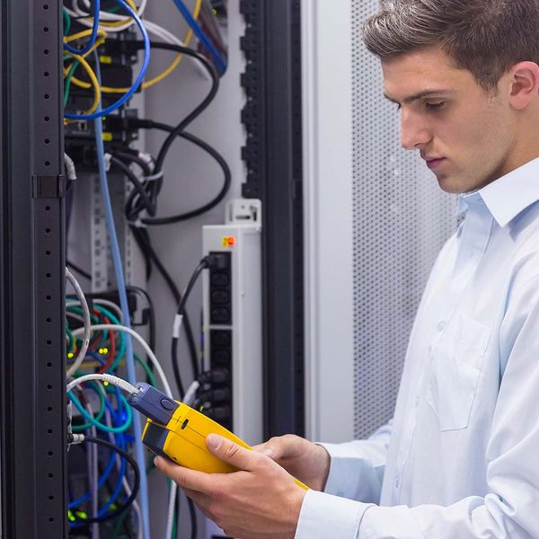 man replacing server in data center