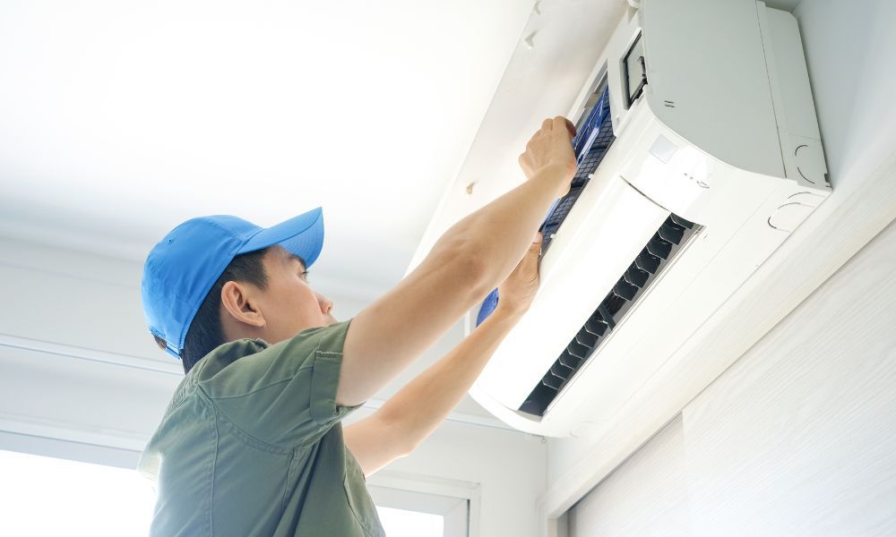 technician adjusting air conditioner