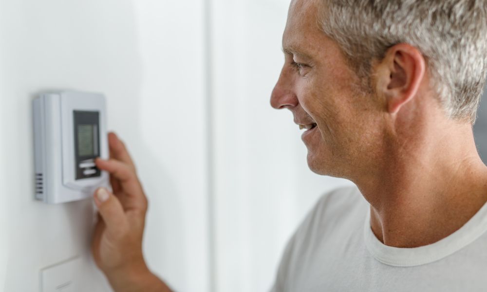 person adjusting thermostat