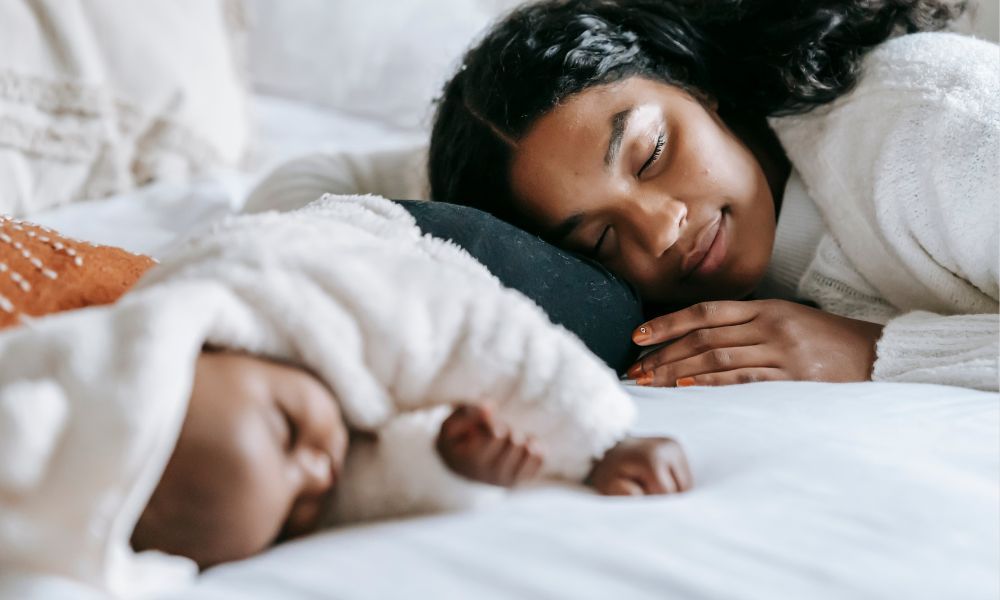 mother sleeping next to baby