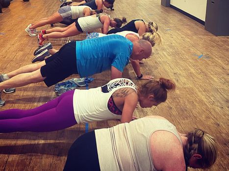 A gym class doing planks.