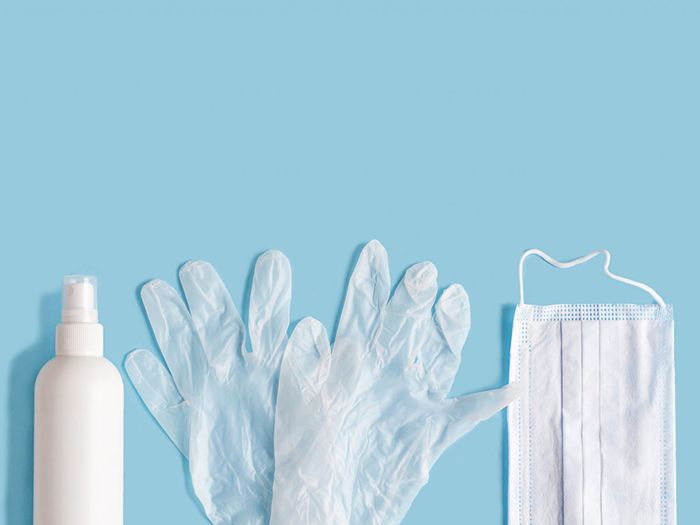 Image of a sanitizer bottle, plastic gloves, and a face mask