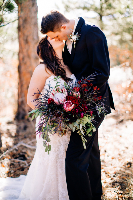 A kiss showing off her bridal bouquet of King Protea. AshleeJackson-286-of-366-5c11469abaaa3.jpg