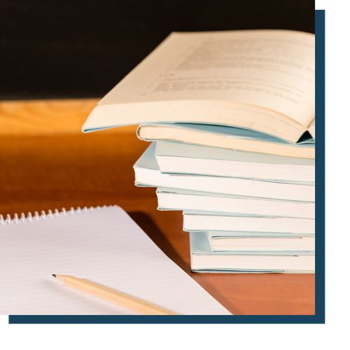 Stack of books next to a notebook