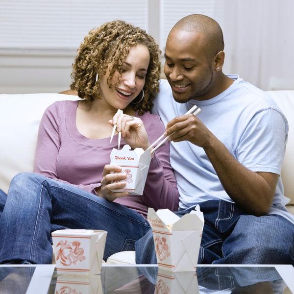 couple eating takeout on couch