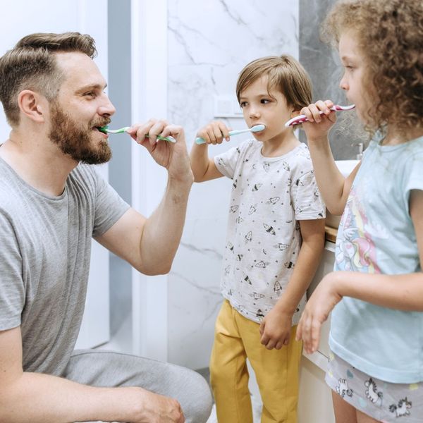 family brushing teeth together in bathroom family brushing teeth together in bathroom
