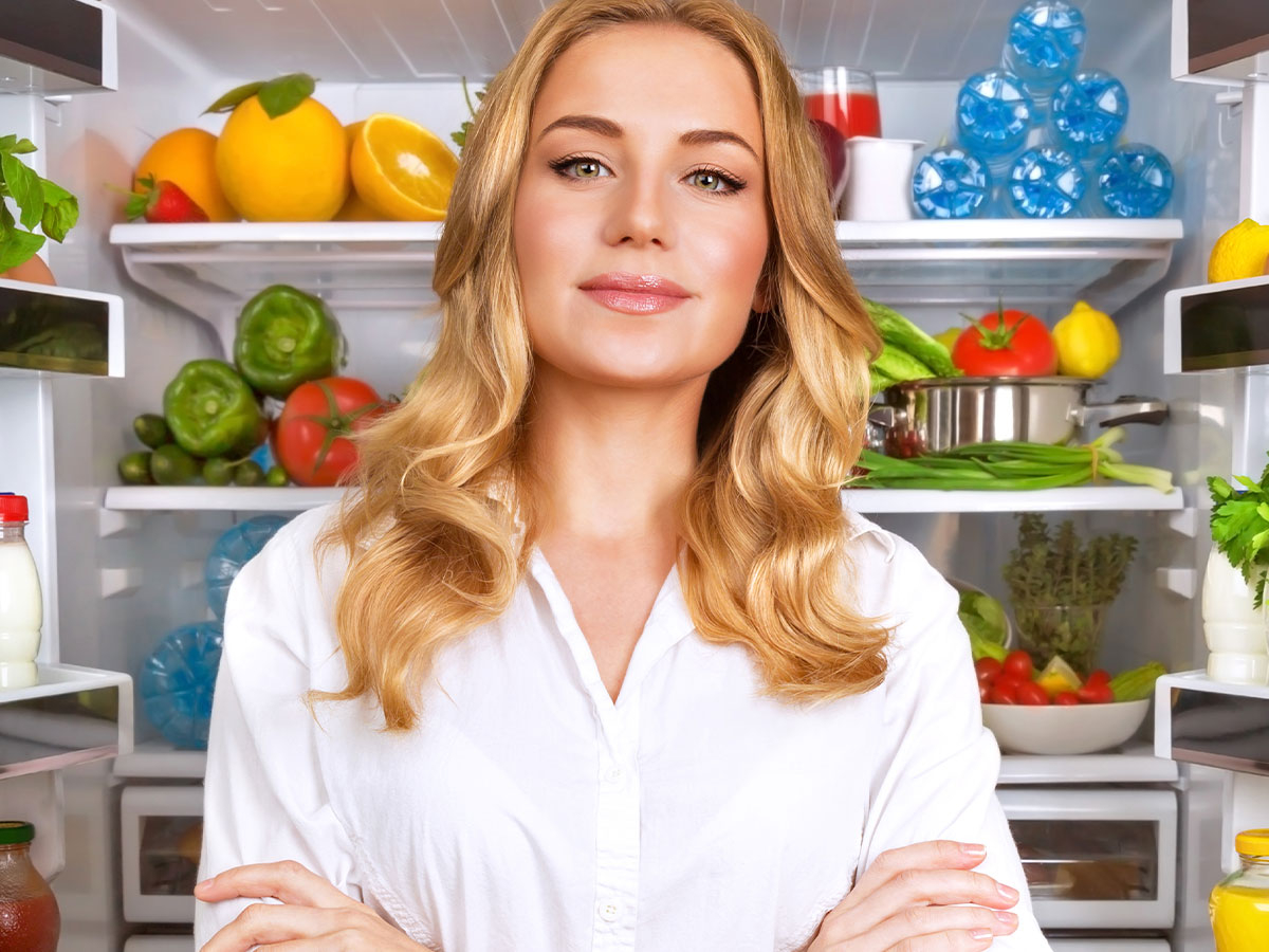a woman standing in front of an open refrigerator