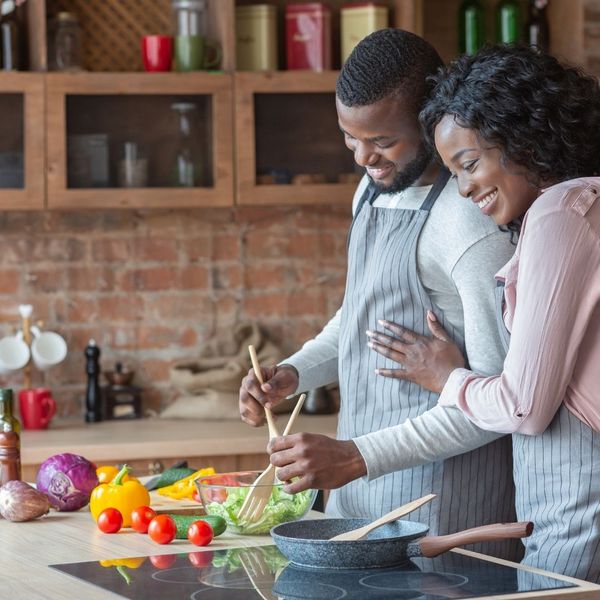 black man and black woman making a meal in their kitchen