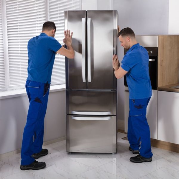 appliance installation technicians moving a refrigerator