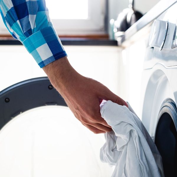 man's hand taking clothes out of dryer