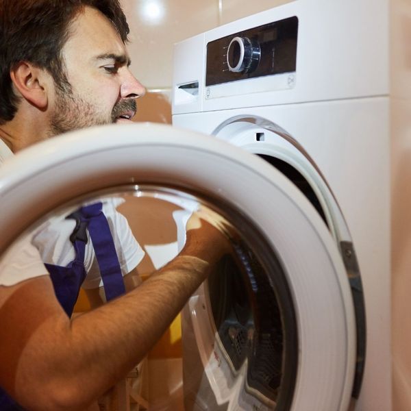 appliance repair technician working on dryer