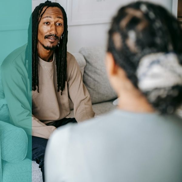 Two therapists speaking to each other in a therapy office.