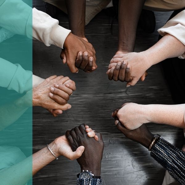 A diverse group of people holding hands in a circle
