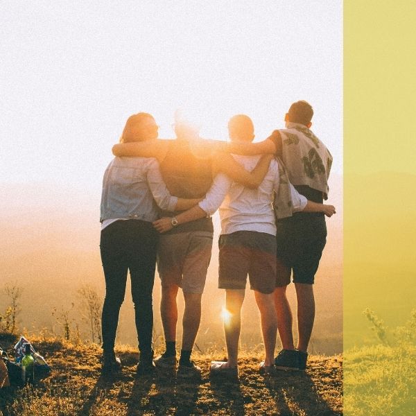 A group of people hugging at the top of a hike