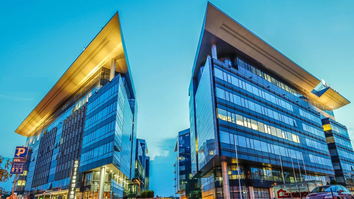 Two office buildings with lights on