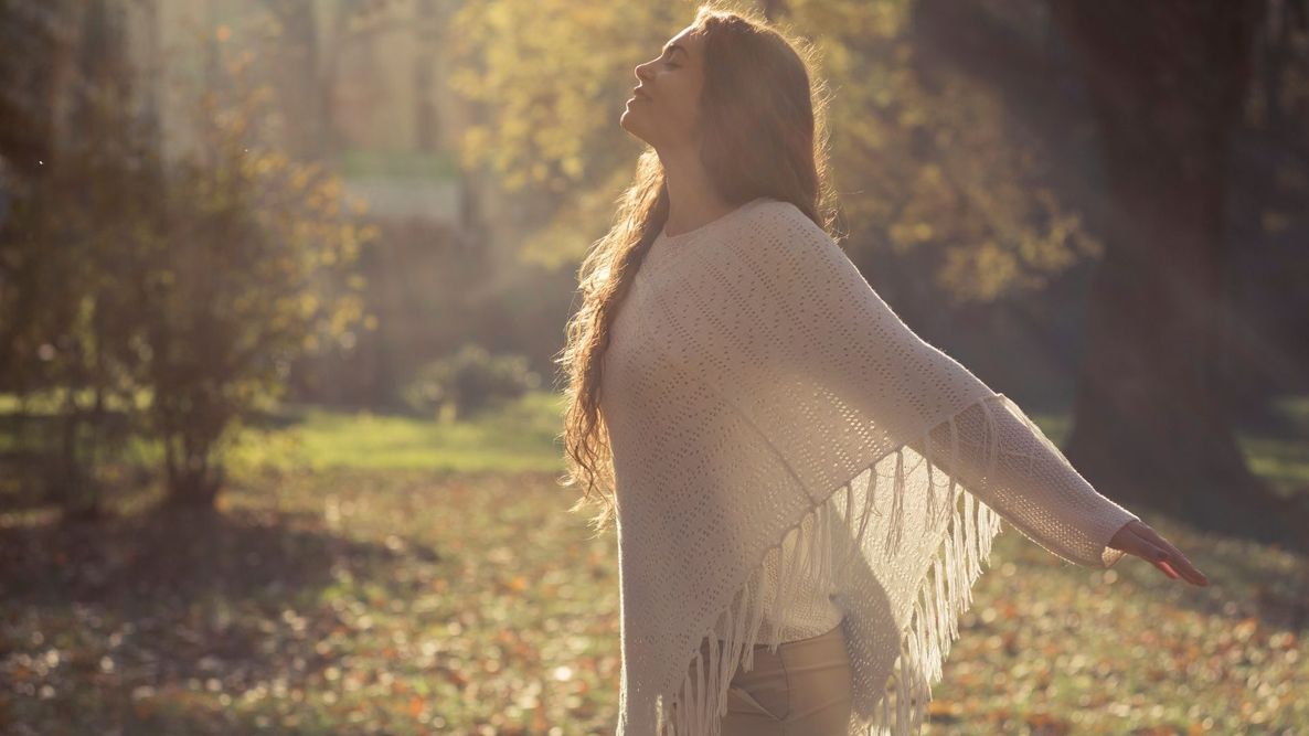 a woman holding her arms out in nature