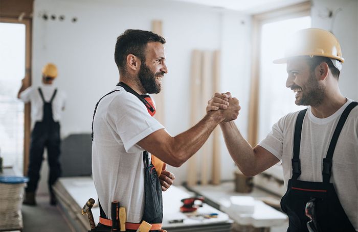 two construction workers shaking hands