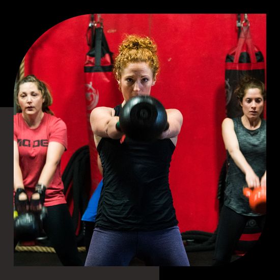 a group of woman lifting kettlebells