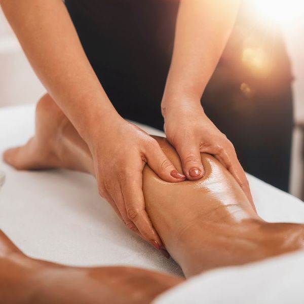 closeup of a woman receiving a deep tissue leg massage