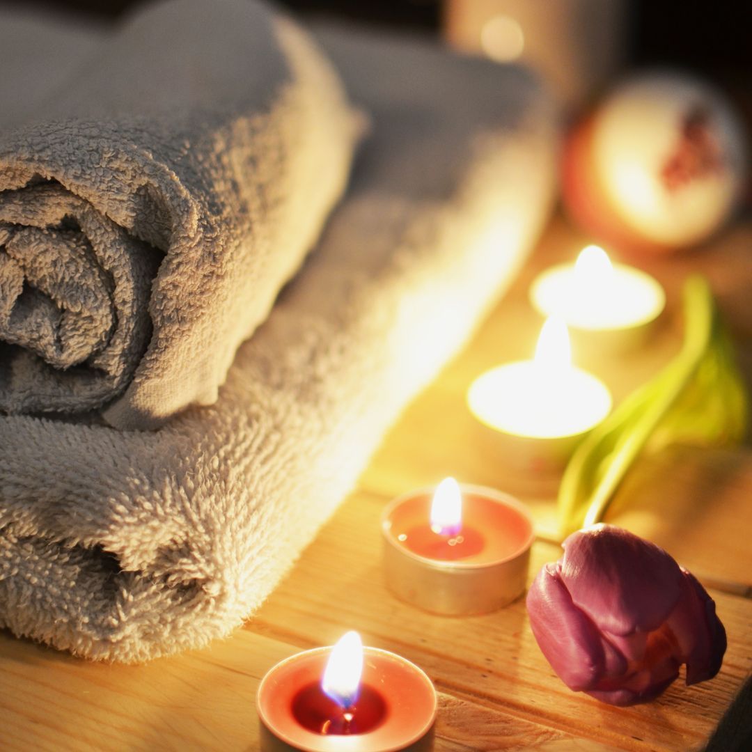 candles and tulip next to massage towels