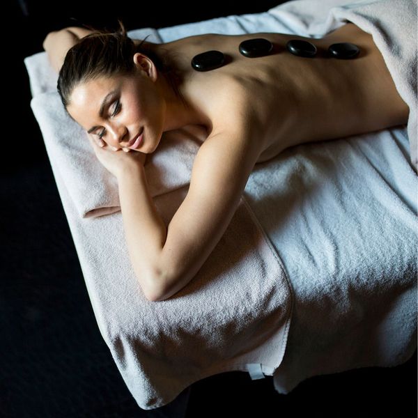closeup of a woman receiving a thai hot stone massage 