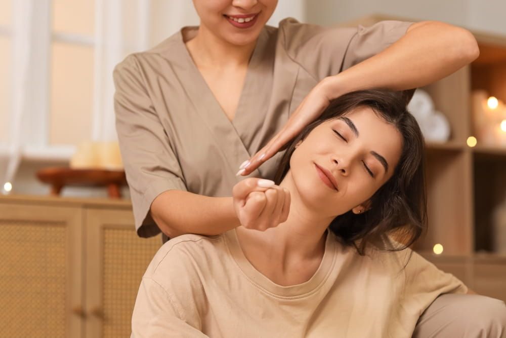 A woman feeling shoulder and neck tension ease at the best massage spa in Plano