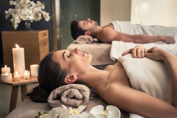 young couple lays next to eachother ahead of a couples massage