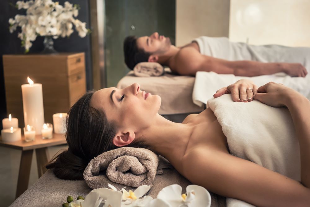 young couple lays next to eachother ahead of a couples massage