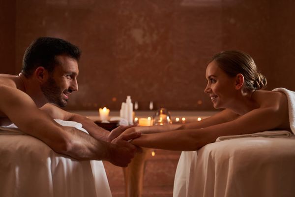Couple connecting during a side-by-side massage, a meaningful indoor date idea