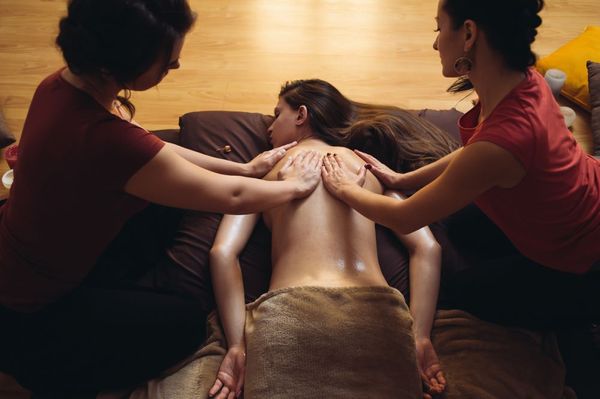 A woman experiences a 4-hand Thai massage