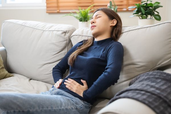 Woman holding her stomach, wondering what helps with period cramps