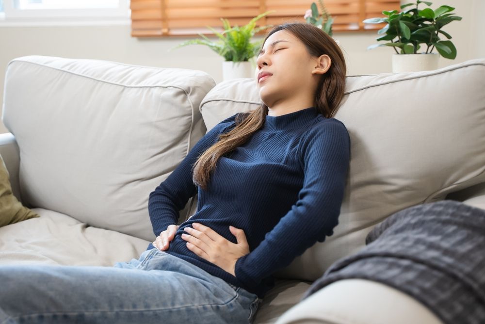 Woman holding her stomach, wondering what helps with period cramps