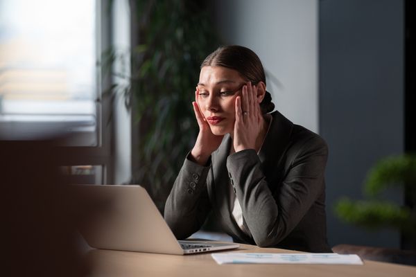 Stressed woman at her desk, in need of relaxing activities for mental health