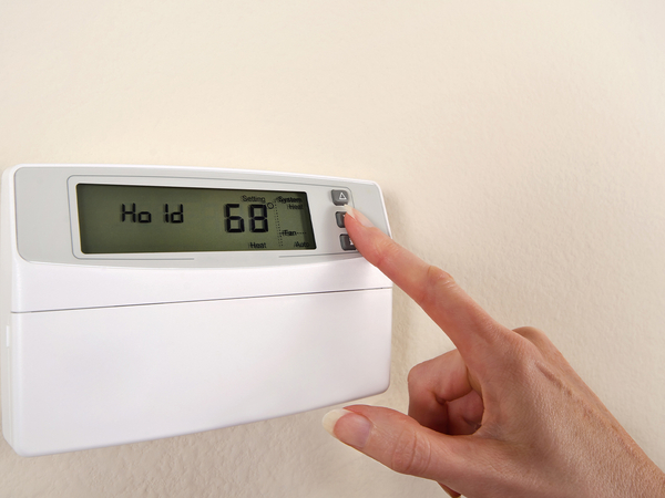  Adjusting and setting thermostat to save energy.